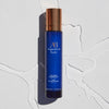 Lifestyle shot top view of Augustinus Bader The Cream Cleansing Gel (100 ml) with water in the background