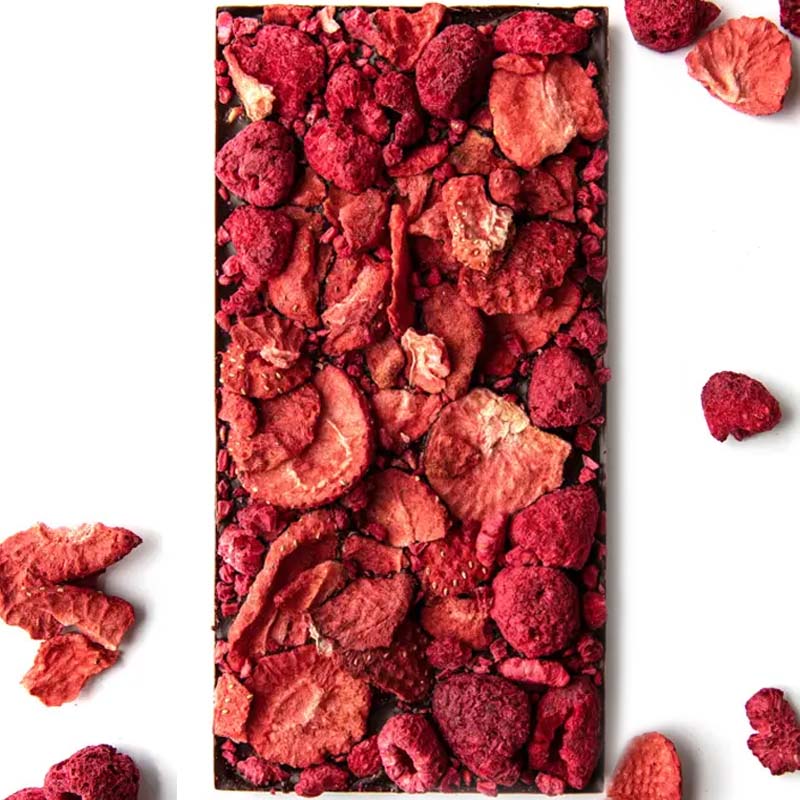 Berry Berry Chocolate (85 g) shown unwrapped with dried strawberry and raspberry pieces in the background
