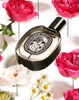 Diptyque Eau Rose De Parfum another angle of  bottle laying flat with flowers 