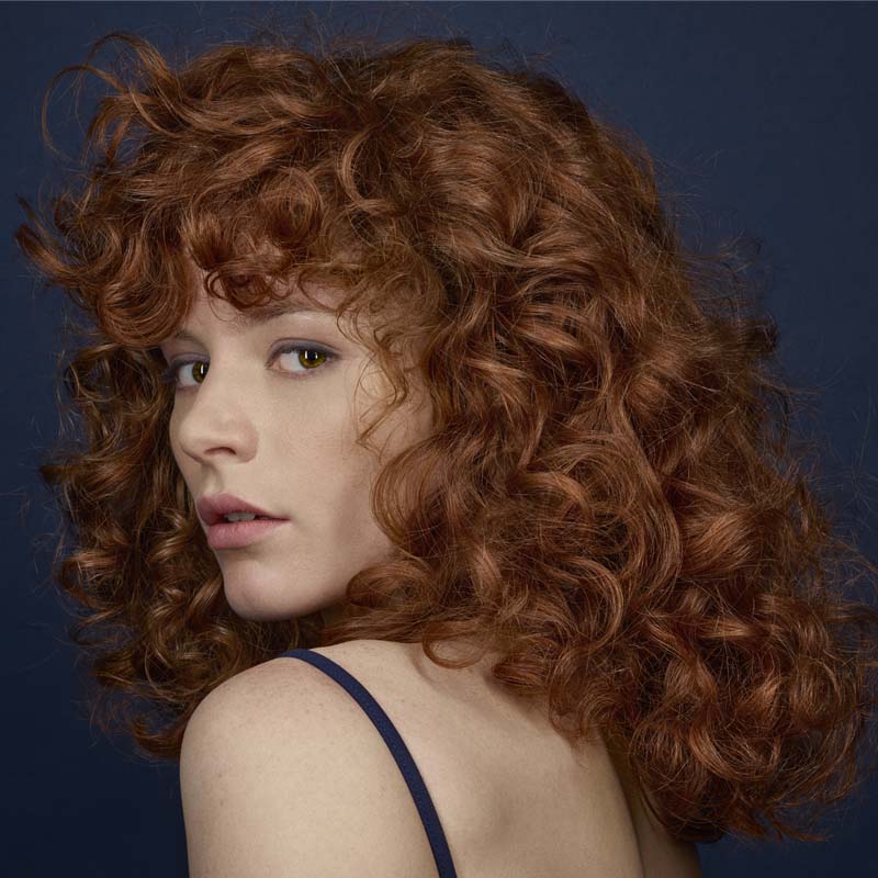 R+Co Bleu Primary Color Masque showing on models curly hair 