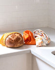 Goldilocks Goods Produce Bags: Golden Floral showing bags on counter and loaf of bread fitting it yellow bag