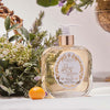 Santa Maria Novella Acqua Della Regina Liquid Soap showing next to floral arrangement