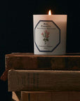 Carriere Freres Damask Rose Candle sitting on 3 brown books