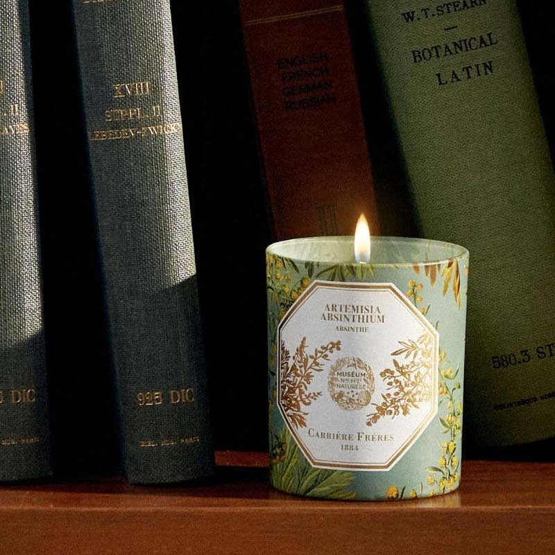 Carriere Freres Absinthe Candle showing on a book shelf surrounded by green books
