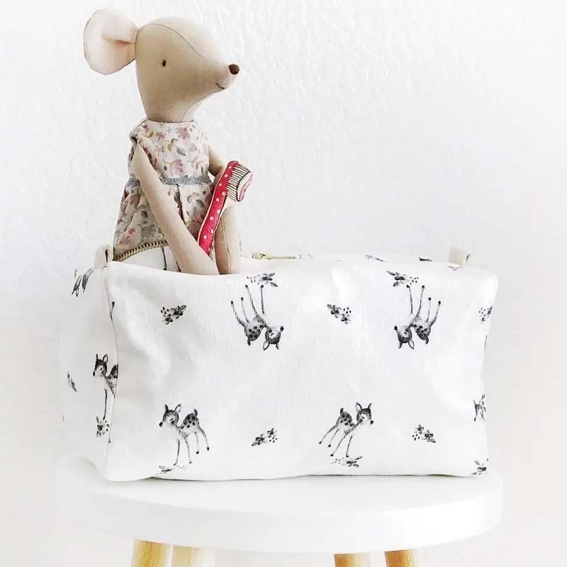 Rose in April Fawn Toiletry Bag  - Beige showing toy sticking out of bag on a stool 