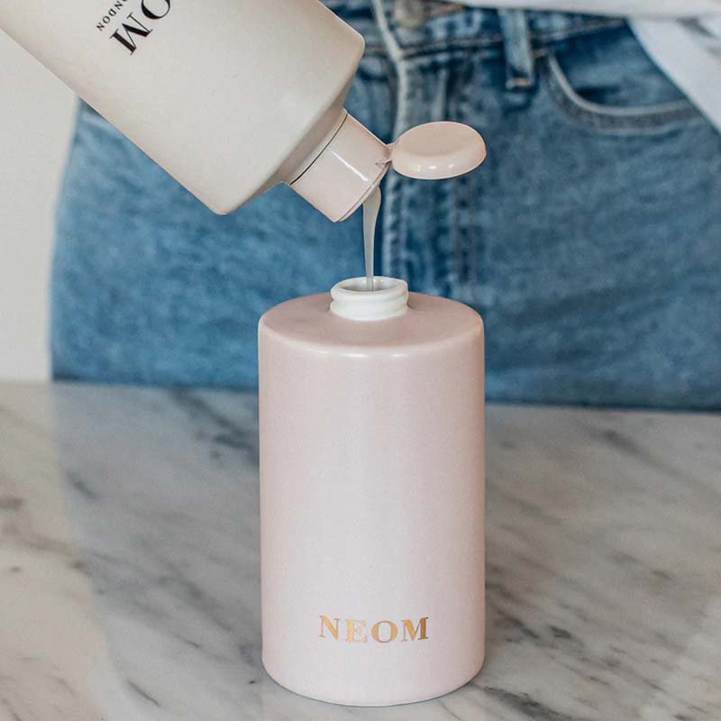 NEOM Organics Real Luxury Ceramic Hand Wash Dispenser &amp; Refill showing product being poured into dispenser