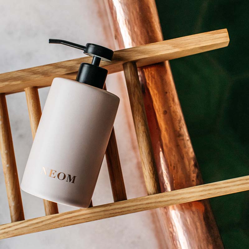 NEOM Organics Real Luxury Ceramic Hand Wash Dispenser &amp; Refill showing on a wooden tray 