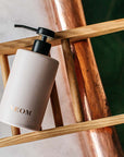 NEOM Organics Real Luxury Ceramic Hand Wash Dispenser & Refill showing on a wooden tray 