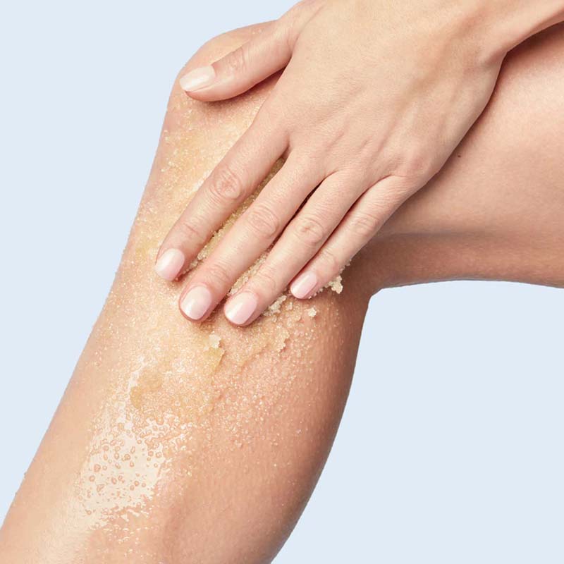 NEOM Organics Real Luxury Body Scrub showing scrub being used on leg