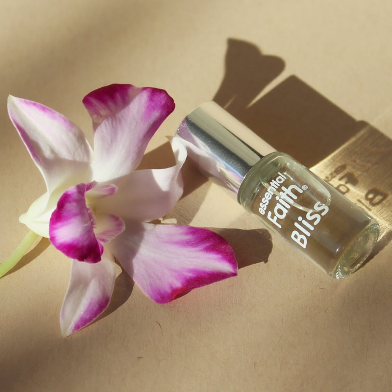 Essential Faith Bliss Roll-On showing with orchid flower