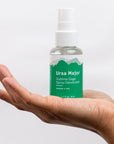 Ursa Major Sublime Sage Spray Deodorant 1.7 oz in palm of model's hand