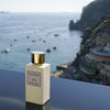 Eau d'Italie Mystic Sunset Eau de Parfum Spray (100 ml) with the Positano cliffside and bay in the background
