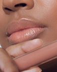 Close up of Roen Beauty Kiss My Liquid Lip Balm - Lola on lips of model with dark skin tone