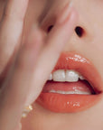 Close up of Roen Beauty Kiss My Liquid Lip Balm – Dodi on lips of model with light skin tone