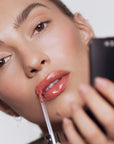 Model applying Roen Beauty Kiss My Liquid Lip Balm – Dodi on lips