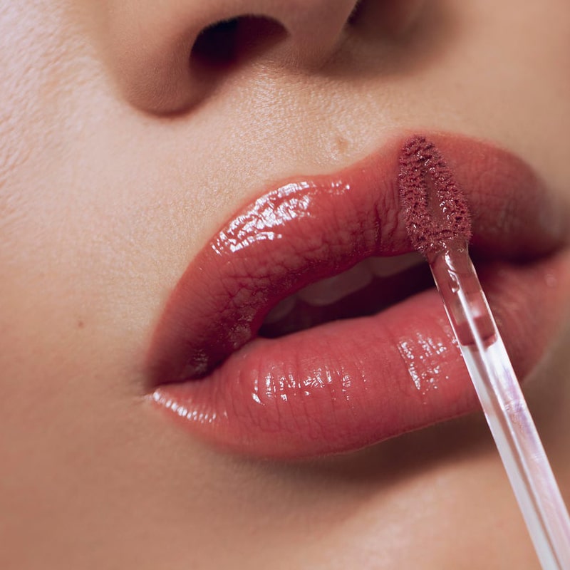 Close up of model applying Roen Beauty Kiss My Liquid Lip Balm – Jude
