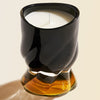 Oribe Cote d'Azur Candle showing black and amber colored glass
