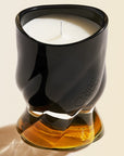 Oribe Cote d'Azur Candle showing black and amber colored glass