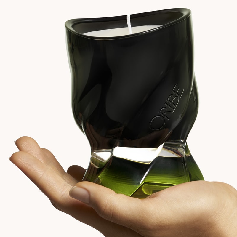 Oribe Desertland Candle showing green glass candle in models hand