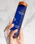 Augustinus Bader The Shampoo showing models hand with soap suds holding product