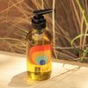 Bathing Culture Heat Wave Body Oil - Nude Beach (4 oz) showing on a piece of wood with plants behind it