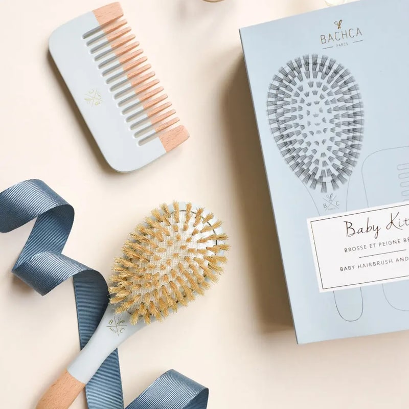 Bachca Baby Kit Hairbrush and Comb – Blue showing packaging with blue comb and blue brush with a blue ribbon