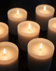 Lifestyle shot of several Child Perfume Scented Candles shown lit against dark background