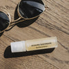 Susanne Kaufmann Eye Rescue Serum beauty shot of tube beside sunglasses (not included)
