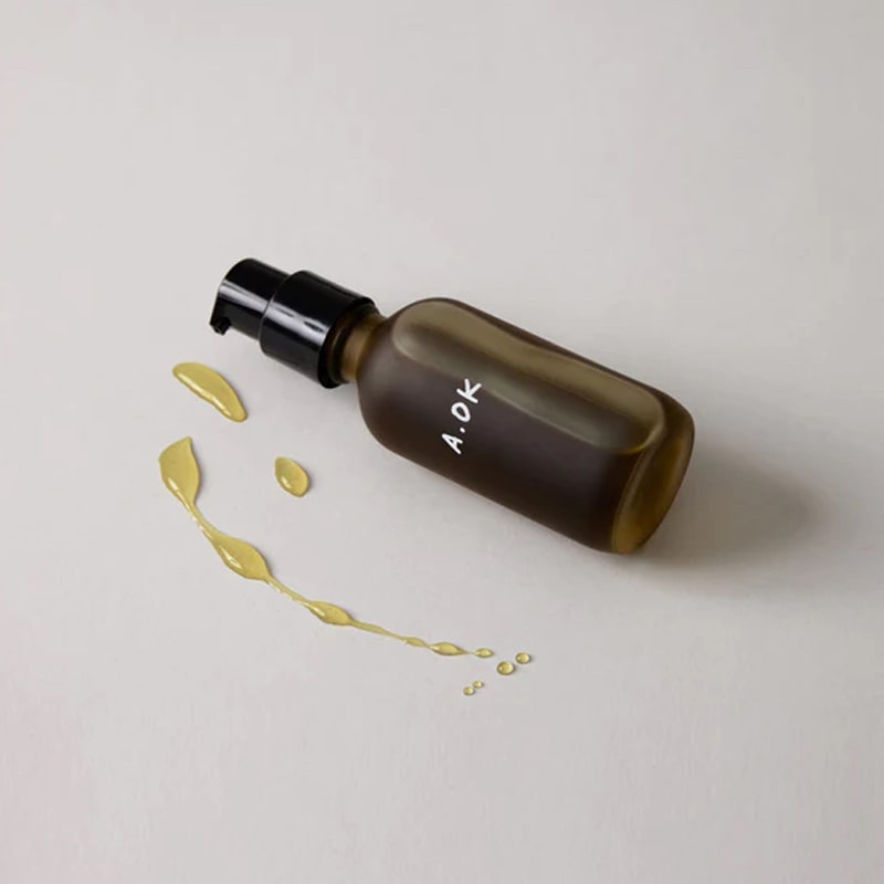 A.OK Body Oil showing spilled oil next to bottle