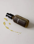 A.OK Body Oil showing spilled oil next to bottle