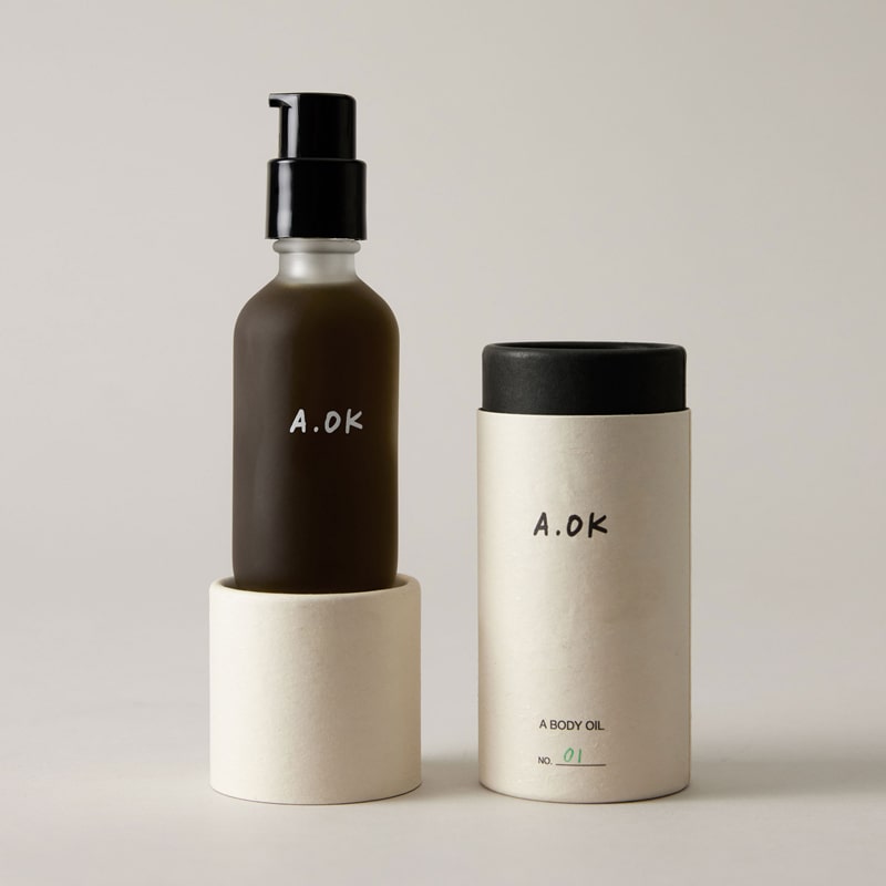 A.OK Body Oil showing sitting on top of lid