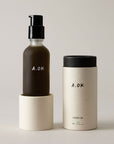 A.OK Body Oil showing sitting on top of lid