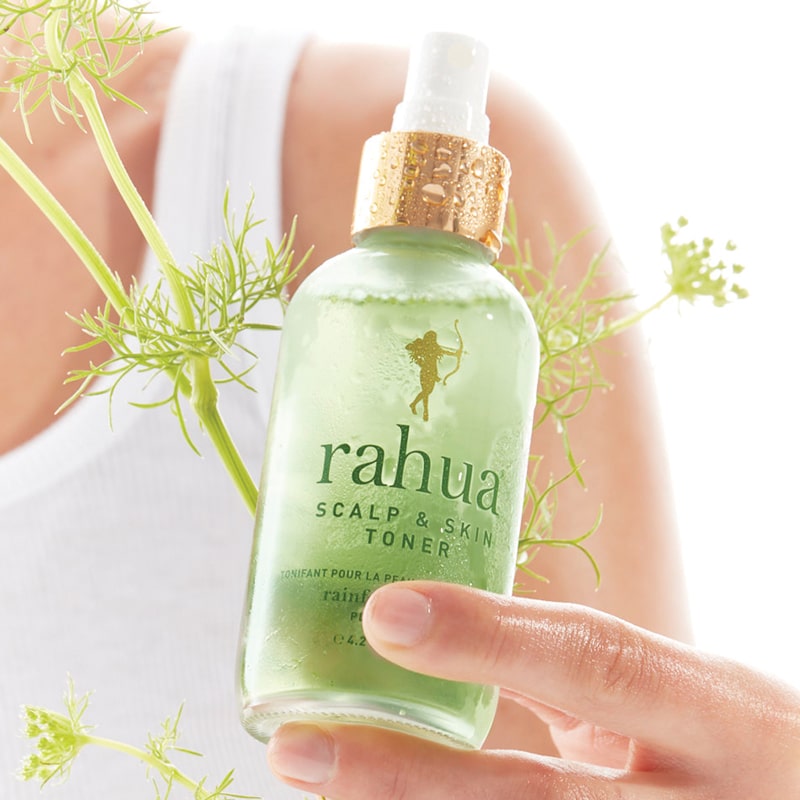 Rahua by Amazon Beauty Scalp &amp; Skin Toner beauty shot in model&#39;s hand with green plant