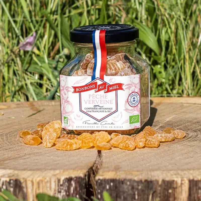 Les Abeilles de Malescot Peach & Verbena Honey Candies beauty shot on tree stump with candies in front of jar