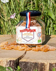 Les Abeilles de Malescot Tangerine & Orange Blossom Honey Candies beauty shot of jar on tree stump with candies in front of jar