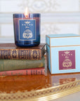 Tocca Beauty Classic Yma Candle beauty shot showing lit candle on top of books with box beside