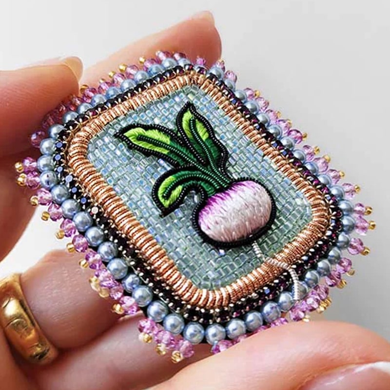 Celeste Mogador Turnip Brooch shown in model's hand for size perspective