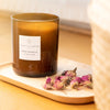 Essential Parfums Rose Magnetic Scented Candle - Product displayed on tray next to flowers