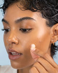 Clean Skin Club DermaDot Acne Patches - Model shown applying product