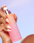 Kosas Plump & Juicy Vegan Collagen Spray-On Serum - Model shown dispensing product with hand