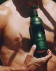 Flamingo Estate Organics Garden Essentials Body Lotion - Product displayed in front of models chest