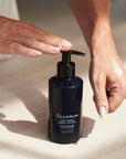 Olverum Soothing Hand Lotion - Model shown dispensing product onto hand