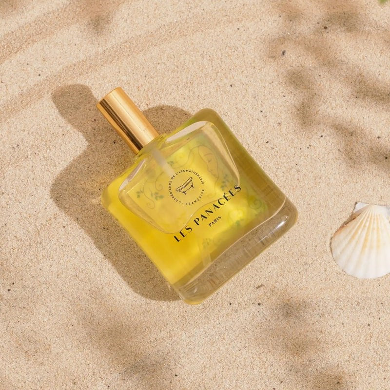 LES PANACEES Nourishing Dry Body and Hair Oil - In the Shade of Cypresses - Product displayed on beach sand