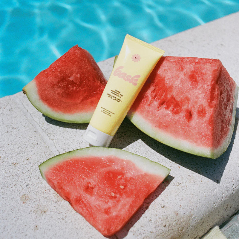 Bask Sunscreen SPF 50 Lotion Sunscreen - Beauty shot, product displayed next to pool and watermelon