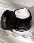 Odacite Jojoba Pearls Daily Hydra-Exfoliant (50 ml) shown with lid off to the side showing exfoliant and exfoliant in the background