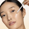 Chantecaille 24K Gold Serum Intense - Model shown applying product to face