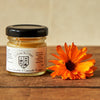 La Ferme de l'Ours Calendula Chamomile Balm - Product displayed next to flower