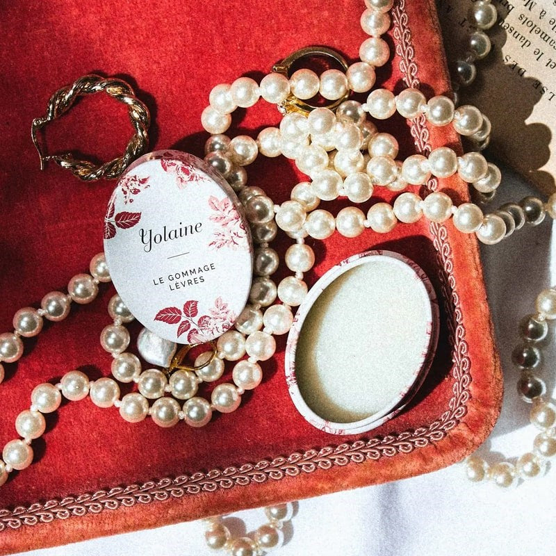 Yolaine The Lip Scrub - Beauty shot - product shown on velvet tray with jewelry