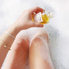 Artifact Mer-Mer Monoi Beauty Flower Glowing Dry Body Oil - Model shown pouring product into bath