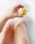 Artifact Mer-Mer Monoi Beauty Flower Glowing Dry Body Oil - Model shown pouring product into bath